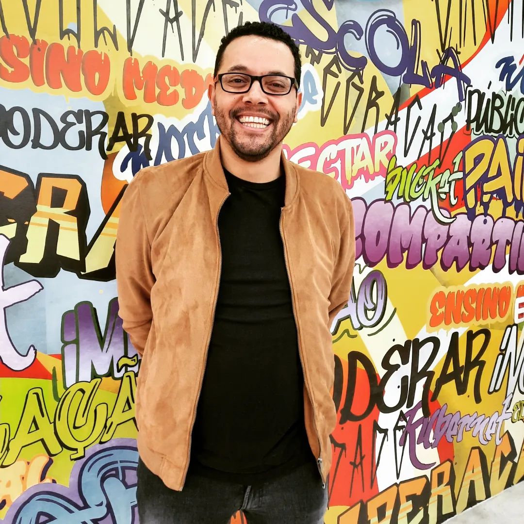 Tônio Caetano diante de um mural de grafite