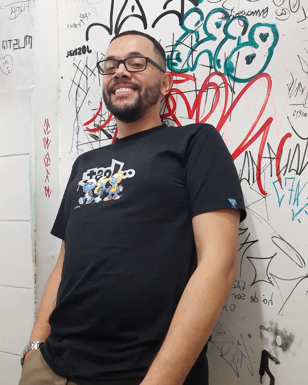 Tônio Caetano diante de parede ilustrada