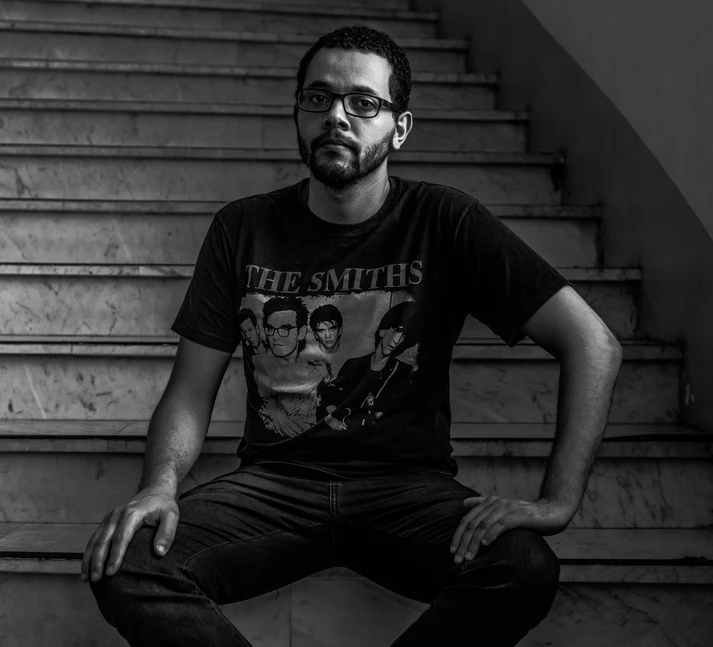 Tônio Caetano sentado em uma escadaria, em preto e branco